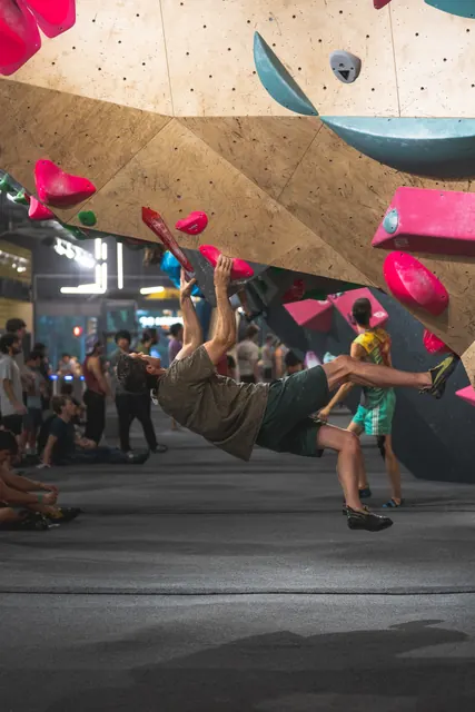 A climber in the middle of a dynamic move on an overhang.